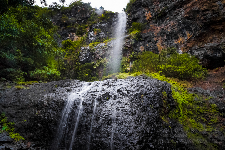 Von Felden über Steine herabfallender Wasserfall im Regenwald